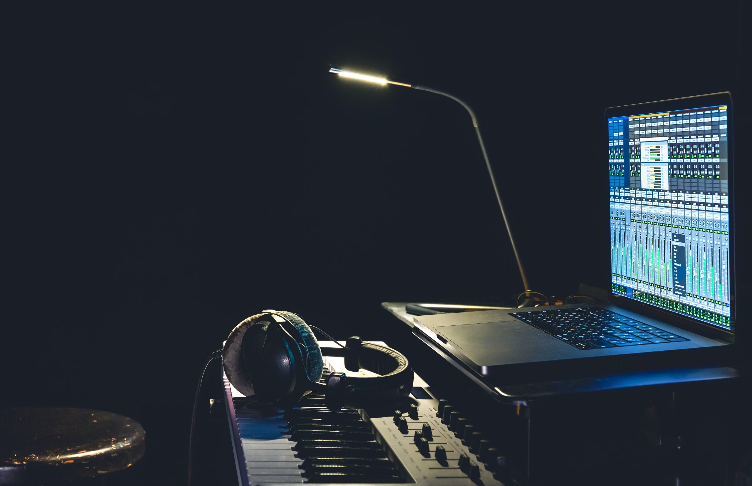 MIDI keyboard, headphones and a laptop with a program for creating music.